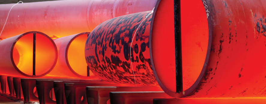 Heat-treated heavy-wall pipe sections glowing red after normalising